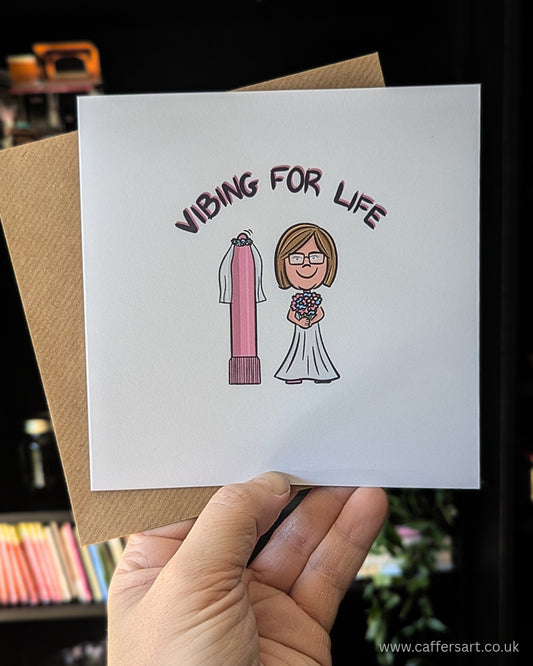 Funny greeting card with cartoon woman in a wedding dress next to pink vibrator wearing a veil, captioned "vibing for life" - perfect for dry humour, self love and adult themed gifts